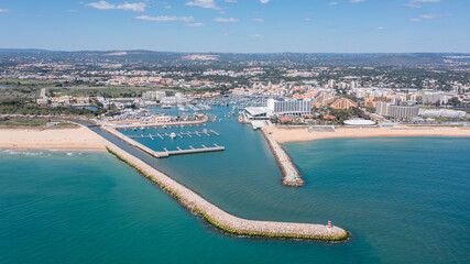 People participate in activities at Vilamoura marina in Algarve, Portugal, with boats docked and a...