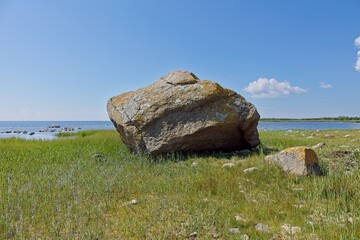 View of Abruka suurkivi boulder on a grassy coastline, which is a massive glacial erratic boulder in summer with clouds in the sky, Abruka, Saaremaa, Estonia. © Raimo Bergroth
