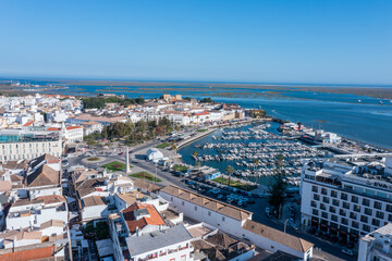 Fototapeta premium Visitors enjoy the lively dock area in Faro, Algarve, where boats are moored. The old town offers views over Ria Formosa and surrounding buildings