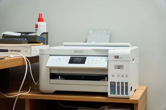 Tyumen, Russia-December 3, 2025: Office setup features a printer epson on a wooden desk with tools nearby and a wall in the background