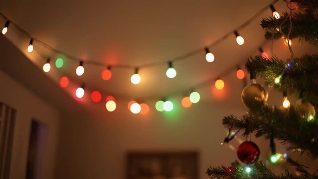 A Christmas tree adorned with colorful lights and ornaments, set against a blurred background with a string of Merry Christmas lights creating a Bokeh effect. Perfect for Christmas, holiday