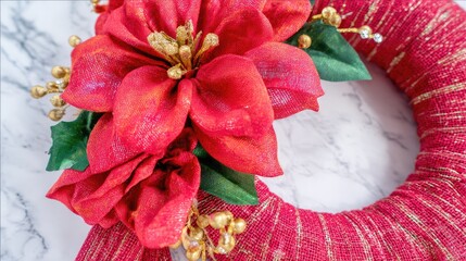 a red burlap wreath with poinsettia and holly leaves