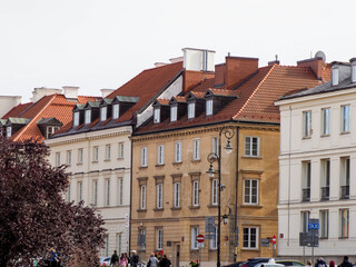 Fototapeta premium Wide view of a row of brightly colored historic tenement houses in the Old Town under a pale sky.