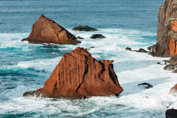 Majestic rocky coastline with rugged cliffs and vibrant turquoise waves crashing against the shore, showcasing the beauty of nature and coastal landscapes