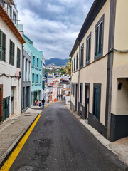 A group of people sit with their backs to the camera on a city street