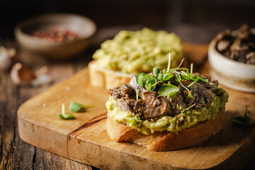 Toast avocado, mushrooms and microgreens whole grain sandwich. Vegetarian food. Vegan menu....