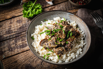 Risotto with mushrooms and herbs on an old wooden background. Rustic style.
