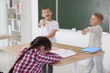 Obraz premium Girl getting bullied by her classmates in school, selective focus