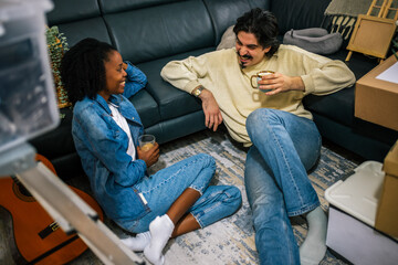 Couple relaxing in new apartment with coffee