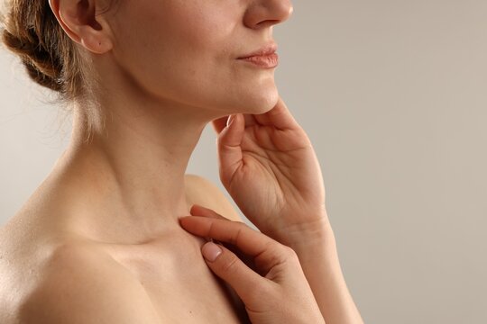 Woman with normal skin on light grey background, closeup. Space for text