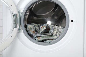 Many dollar banknotes in washing machine, closeup