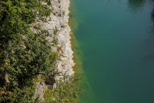 dettagli delle sponde rocciose e delle acque tranquille color verde smeraldo del fiume Isonzo, in Slovenia, di giorno, in estate