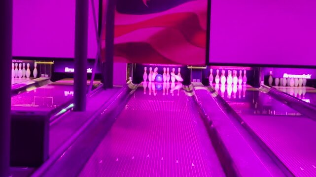 Enthusiast people playing indoor bowling in game zone. Copyspace 4K video of Background gaming zone. Entertainment hobby team game.