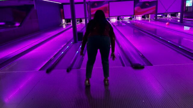 Enthusiast people playing indoor bowling in game zone. Copyspace 4K video of Background gaming zone. Entertainment hobby team game.