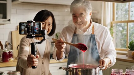 Asian Elderly Couple Recording Cooking Vlog in Home Kitchen for Food Blogs, Recipes, Healthy Eating Websites, and Cooking Tips