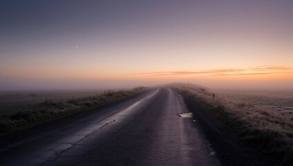 Foggy sunrise over empty rural road stretching into distance, misty morning landscape with orange purple sky, peaceful countryside scene