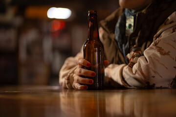 Close up of Woman's Hands Holding Beer Bottle at Bar in Rustic Rural Western Saloon Bar