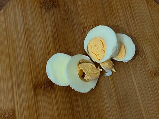 Warm natural lighting highlights peeled eggs on rustic board