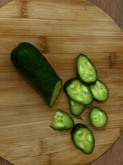 Sliced cucumber on wooden board, food styling still life
