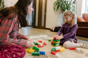 Mother and child building with colorful blocks in cozy home setting © 4Max