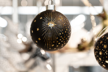 Schwarze Christbaumkugel mit goldenen Sternen