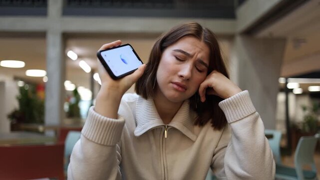 Young woman listens to an unexpectedly honest insight from artificial intelligence helping her reflect on her life choices as she sits in a cafe with a tense uncertain expression
