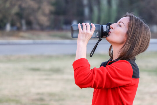 Healthy Middle-Aged Woman Drinking Water Outdoors to Stay Hydrated, Copy Space