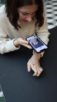 Vertical screen girl shows a bleeding cut on her hand to ChatGPT worried it will ruin her important day asking for quick calm guidance and first aid to manage the pain and stop the bleeding