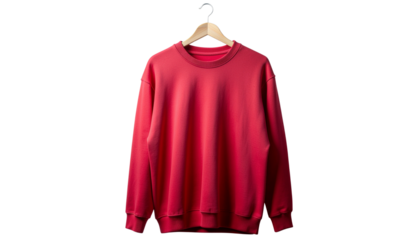 A bright red long sleeved sweatshirt hangs on a wooden hanger suspended against a plain backdrop of solid color pure white background cutout