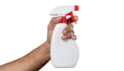 Hand holding a white plastic spray bottle with a red nozzle and trigger mechanism ready for use in cleaning isolated on white