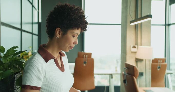 Lady carefully examines files inside vibrant yellow folder near window