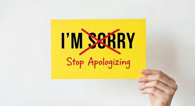 Hand holding a bright yellow sign with bold red text stating "Stop Apologizing," conveying a message of empowerment and self-assertion, challenging the culture of excessive apologies