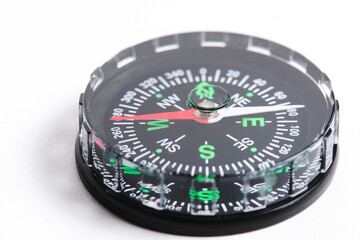 Compass is highlighted on white background in close up. Focus on tip arrow.
