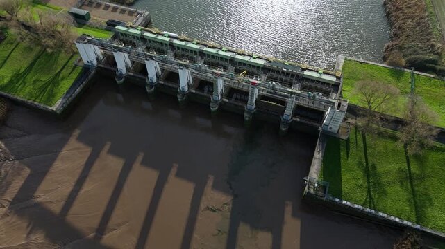 Wide drone view of Tail Sluice hydraulic barrier on the River Nene near Kings Lynn UK showing tidal gates, water flow control and extensive hydro engineering