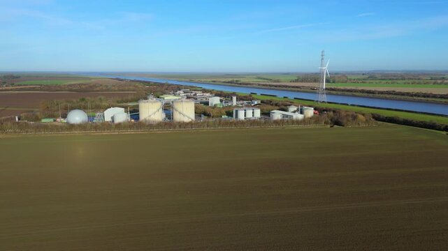 Industrial aerial drone scene of Anglian Water biosolids complex with sanitation infrastructure, sewage processing, tanks and ponds around Kings Lynn UK