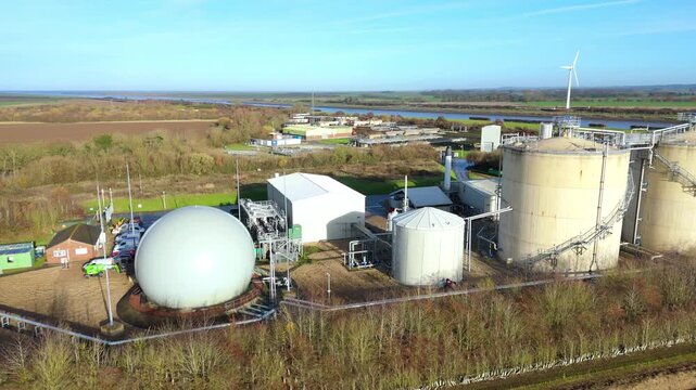 Aerial drone view of Anglian Water biosolids treatment facility with sewage processing tanks, sanitation systems, and settling ponds near Kings Lynn in rural UK landscape