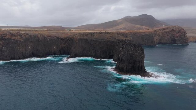 Powerful ocean waves crashing against the volcanic cliffs of Roque Partido in Gran Canaria