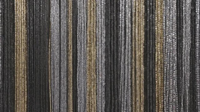 Colorful hematite beads hang evenly on strings, shimmering as they await use in handcrafted jewelry projects.