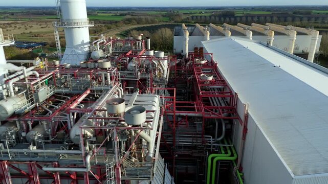 Close up Aerial drone view of Industrial power plant infrastructure, mechanical piping and vents of chimney stack and powerhouse, Sutton Bridge, UK.