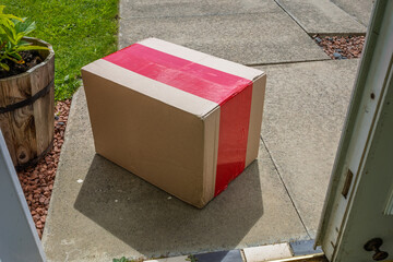 Online shopping parcel delivery left on doorstep with open porch door from inside