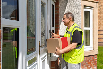 Side View of Courier Pressing Doorbell While Holding Parcel at Front Door