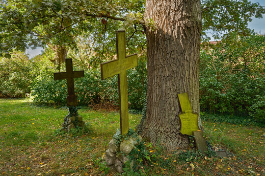 Verwitterte metallene Grabkreuze auf dem Friedhof der denkmalgesch&uuml;tzten Dorfkirche in Bechlin, einem Ortsteil von Neuruppin