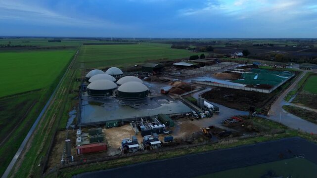 Aerial drone view of rural biogas energy plant, power station using renewable agricultural waste in countryside, domes and electricity generation near Wisbech, UK
