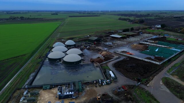 Aerial drone view of rural biogas energy plant, power station using renewable agricultural waste in countryside, domes and electricity generation near Wisbech, UK