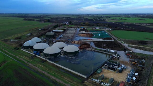 Aerial drone view of rural biogas energy plant, power station using renewable agricultural waste in countryside, domes and electricity generation near Wisbech, UK