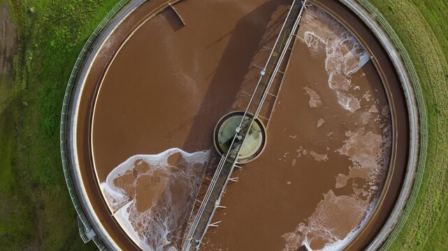 Aerial drone perspective of radial circular clarifying tanks, waste water from factory production line cooling, brown sewage. Top down view.