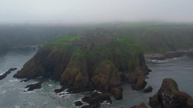 Aerial view of the ruined Dunnottar Castle surrounded by mist on the Aberdeenshire coast of Scotland