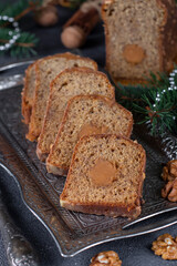 Christmas cake with nuts and salted caramel, covered with chocolate glaze on holiday background