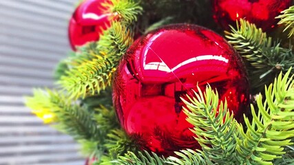 Shiny red ball hang from a decorated Christmas tree in work office, store, autre works local.
