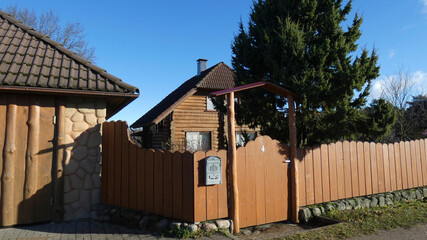 Wooden house and fence in a rural area with a clear blue sky during the day